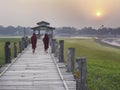 Burmese monks walking across the U Bein Bridge at sunset